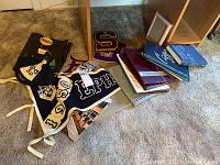 Overview of yearbooks, pennants, sorority handmade book, letterman items, and school memorabilia on a carpeted floor.