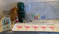 Wide view of the lot showing serving tray, tiki mug, shot glasses, and collectible tins.