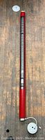 Full length image of the red mid century modern hanging light fixture with cord and ceiling plate on wood floor