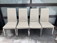 Frontal view of 4 gray upholstered Italian side chairs with chrome frames showing upholstery wear and clean chrome legs.