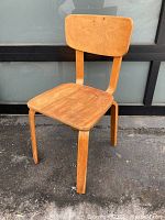 Front view of a wooden mid century modern bent wood chair showing seat and backrest.