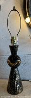 Full view of the vintage black and gold mid century modern lamp showing height and overall shape.