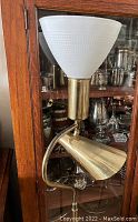 Full view of lamp showing milk glass shade, adjustable reading lamp, and brass finish.