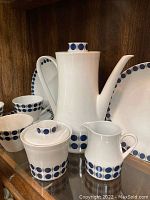 Photo showing coffee pot, sugar bowl, creamer with lid and blue dot pattern