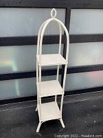Full view of the tall etagere shelf showing its full height and side profile against a backdrop.