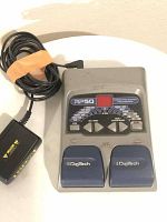 Top view of DigiTech RP50 multi effects pedal with attached power adapter, placed on white surface. Visible wear and coiled power cable taped with orange rubber band.