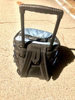 Rear view showing black padded backpack straps and extending handle fully extended upwards