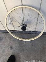 Full view of 26-inch bicycle wheel with white rim and spokes.