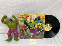 Photo showing the green Hulk figurine next to the vinyl record with illustrated cover