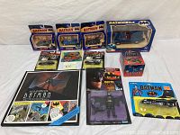 Overview photo showing all items in the lot including die-cast vehicles, trading cards, and pop-up book, mostly factory sealed.
