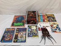 A collection of nine 1990s comic books including Sludge, Unity Saga hardcover, and others.