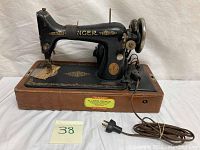 Full view of 19th century Singer sewing machine on wooden base with electric cord and plug