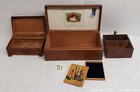 Lot contents shown together including four wooden boxes of varying sizes and styles on a white background.