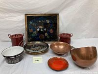 Full shot of the lot showing framed foil artwork, enamelware pots, copper bowls, and a small dish.