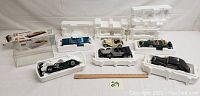 Six diecast model cars in styrofoam trays and one clear plastic display cover alongside branded cardboard sleeves