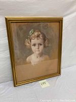 Framed pastel portrait of a young girl with curly hair and a green bow.