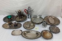 Full view of the lot showing all silverplated items arranged on white backdrop.