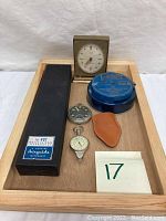 Lot items on wooden tray: clock, bank tin, two stopwatches, Aeroguide boxed instrument