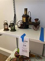 Overview showing painted metal steam cart on right with two glass brass lanterns on left