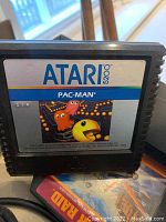Close-up of Atari 5200 Pac-Man game cartridge focused on label with colorful characters in maze game scene