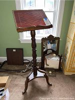 Front view of the vintage wooden colonial style music stand with red leather top