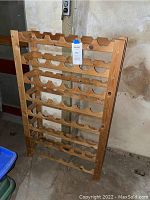 Front view of wooden wine rack showing rows and slots for bottles.