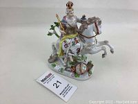 Porcelain figurine of a crowned rider on rearing horse with number card.