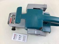 Top view of the Makita belt sander, showing the front handle and metal body with label.