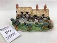 Front view of Norwich Anne Hathaway Cottage collectible model with visible thatched roof, chimneys, and garden