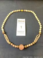 Full view of vintage pink jade beaded necklace showing the entire length and closure clasp.