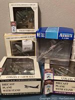 Six die cast model planes in original packaging, some boxes show damage. Includes Postage Stamp Planes sets and an Armour Collection model.