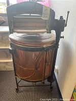 Front view of the copper electric washer with mangle, showing the machine body and frame.