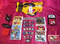 Full lot arranged on pink background showing DS console, case, chargers, games, Nerf blaster and Roku unit