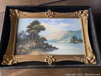 Frontal image of the framed pastel artwork showing the scenic landscape with trees, lake, and mountains in a gold ornate frame and black shadow box.