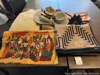 Overview of lot showing blankets, textile, hats, pouch and binoculars