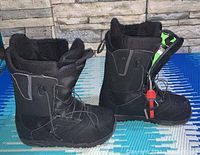 Side view of pair of black Burton Ruler snowboard boots showing quick lace system and padded ankle support.