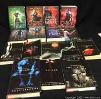 Collection of 15 fantasy genre books by Sarah J. Maas and Kelley Armstrong laid out on black background showing covers