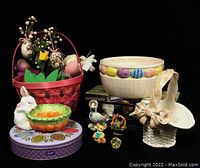 Full view of the Easter collection including a large decorated bowl, candy dish, bunny bowl, ceramic basket, red Easter basket with assorted egg decorations, and small figurines.