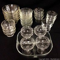 Various glass bowls including Pyrex, cereal, dessert, embossed crystal, and assorted bowls, arranged with the serving tray underneath.