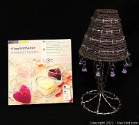 Photo showing four heart-shaped scented tea light holders in packaging alongside the purple bead and metal decorative lampshade.