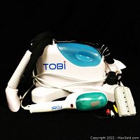 Main steamer unit with hand-held steamer, hose, and fabric brush attachments laid out on black background.