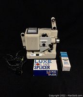 Overall view of Eumig Wien Type P8 vintage projector with Luxe roll tape splicer and replacement lamp box.
