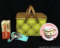 Lot contents showing all three items: a vintage yellow plaid metal picnic basket with handles, a blue metal wall mount can opener with original box, and a pink polka dot ceramic wall mount plant holder with a girl's face portrait.