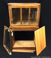 Two large wooden hinged boxes and unfinished shelf unit displayed against black background.