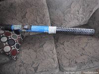 Full view of rolled up G-Floor grilling mat on couch in packaging