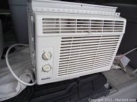 Side-front view of Danby window air conditioner showing front vents, control knobs, brand name, and power cord.