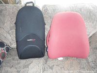 Two back support cushions on a couch, one black and one red, showing general shapes and colors.