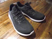 Top side view of the new black Skechers shoes with mesh uppers and laces.