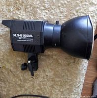 Side view of the strobe light showing model number SLS-6160ML and reflector cowl with dents.