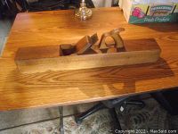 Wide shot of the full length vintage wooden block plane showing overall shape and size on wooden table.